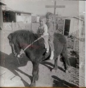 Donna with her older sister, Leah on their first pony, Christmas