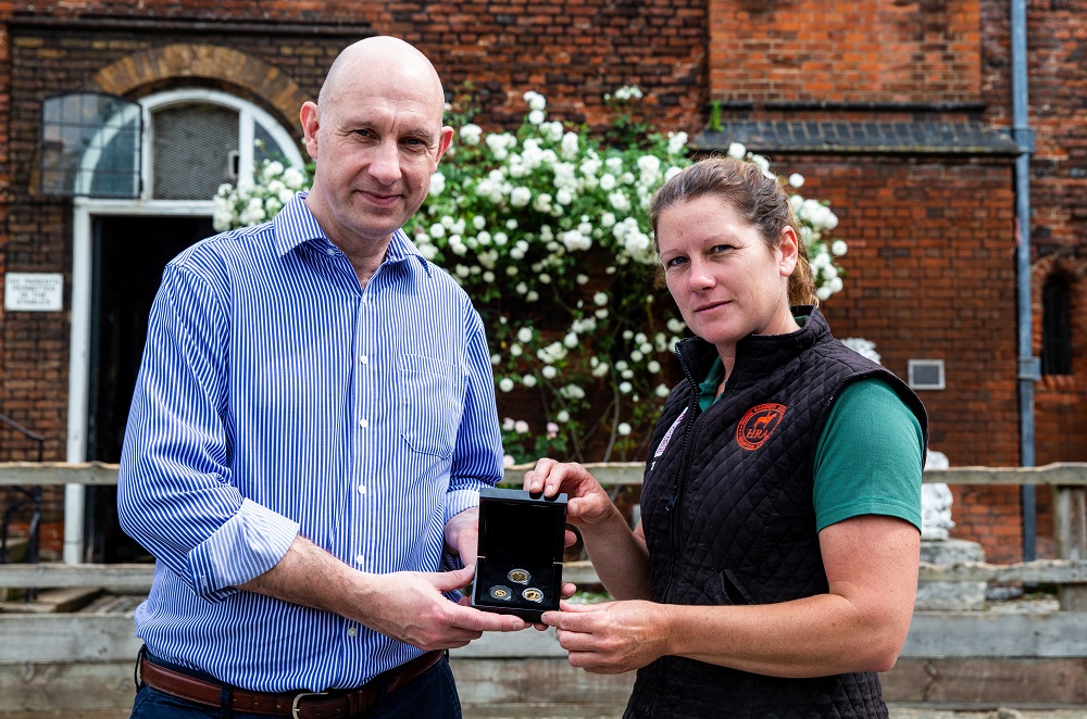 Stephen Lee, managing director of Bradford Exchange presents to Theresa Barrett, stable manager of The Horse Rangers Association, during the launch of the gold quarter sovereign to feature the portrait of the Queen on horseback, released by Bradford Exchange at the Horse Rangers Association, Royal Mews, Surrey. Photo credit: Steven Paston/Press Association. Stephen Lee, managing director of Bradford Exchange presents to Theresa Barrett, stable manager of The Horse Rangers Association, during the launch of the gold quarter sovereign to feature the portrait of the Queen on horseback, released by Bradford Exchange at the Horse Rangers Association, Royal Mews, Surrey. Photo credit: Steven Paston/Press Association.
